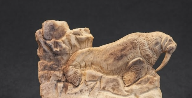 Stone carving of a walrus on a dark background