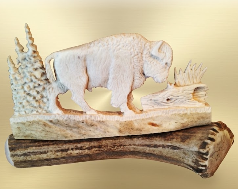 Bison antler carving on an antler with cream background