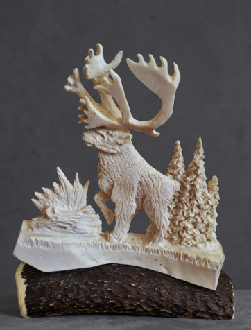 Carved caribou figure with antlers on a dark background