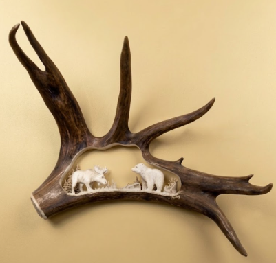 Decorative antler with carvings of animals on a beige background