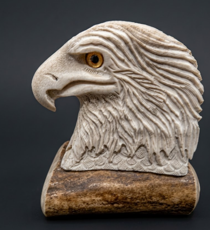 Carved stone eagle head on a dark background