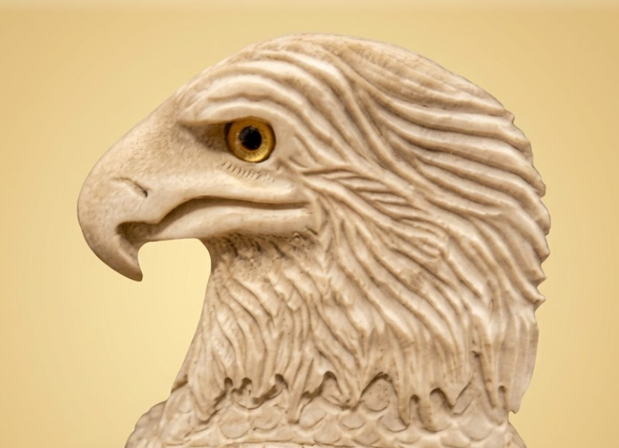 Carved stone eagle head on a beige background