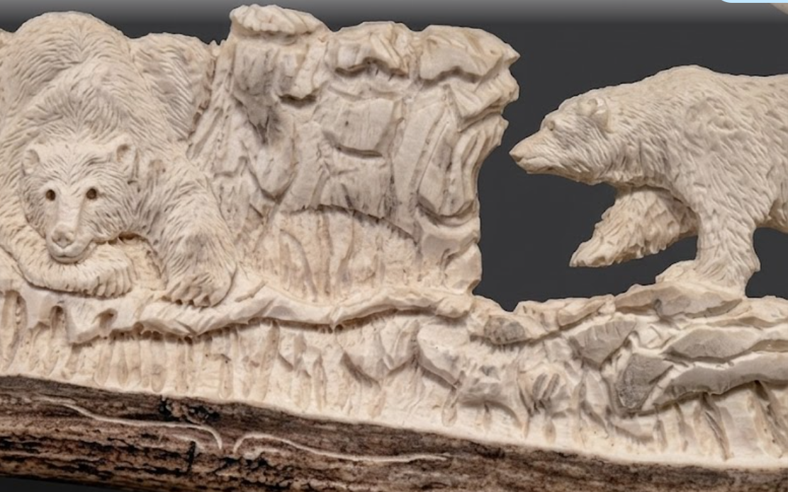 Carved stone panel with two bears and a mountainous landscape