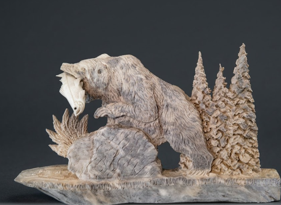 Carved stone bear sculpture with a naturalistic design on a dark background