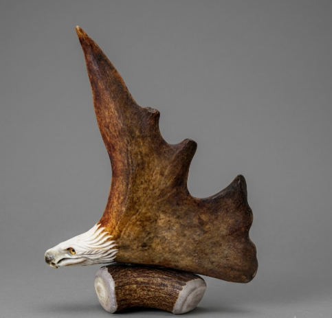 Decorative sculpture of a antler carving  eagle head on a gray background