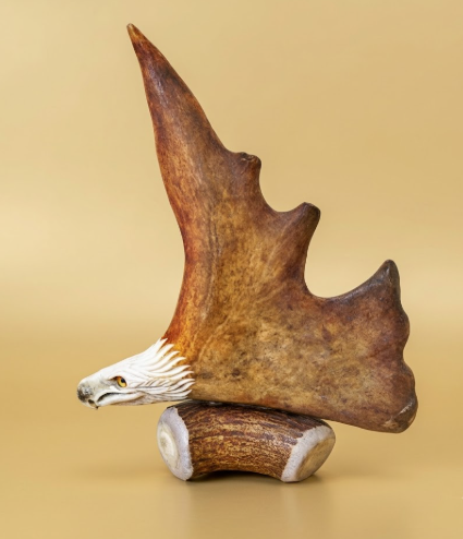antler carving sculpture of a resting eagle on a beige background