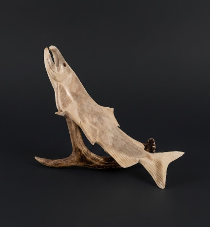 Wooden sculpture of a fish on a dark background