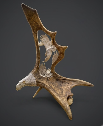 Decorative antler with engraved eagle design on a dark background