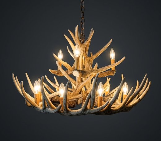 faux deer Antler chandelier with multiple lights on a dark background