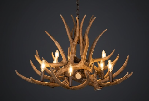 faux deer Antler chandelier with multiple lights on a dark background
