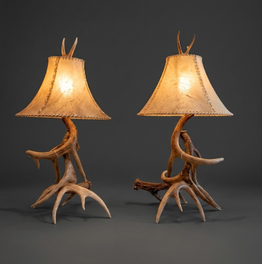 Two table lamps with antler bases on a dark background