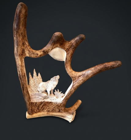 Decorative antler carving with carvings of animals on a dark background