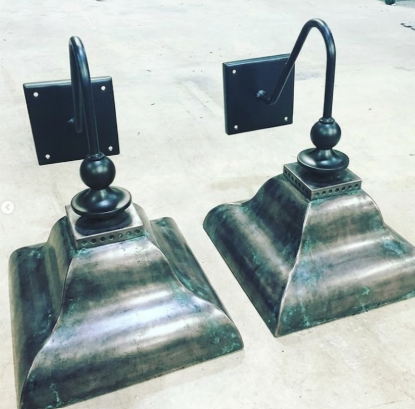 Two copper wall sconces on a light background