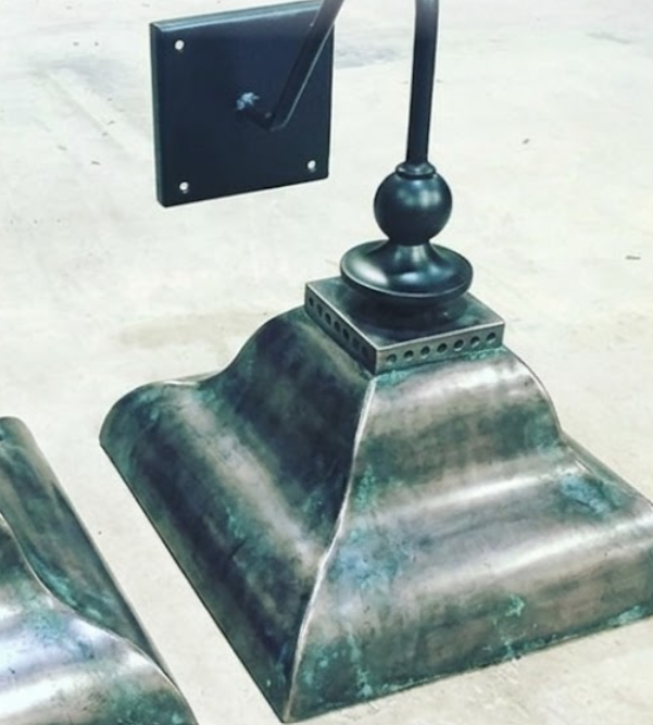 Copper wall sconces on the floorMetal roof finial with decorative design on a white background