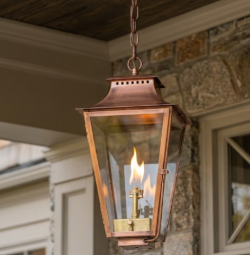foyer entryway pendant light outdoor gas lantern hanging in front of a glass and wood foor witha grey rock wall background