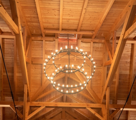  3 tier foyer entryway pendant light chandelier hanging from a wooden ceiling with exposed beams