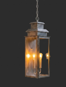 Vintage-style Copper foyer entryway pendant light with two lit bulbs with glass panels on a dark background 
