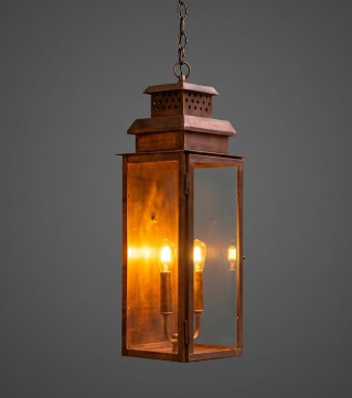 Copper foyer entryway pendant light with two lit bulbs with glass panels on a dark background