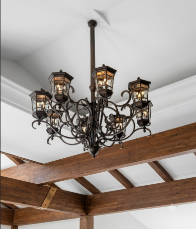Decorative entryway chandeliers hanging from a ceiling with wooden beams