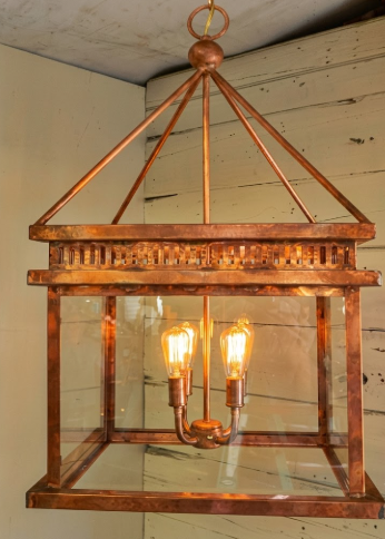 Copper kitchen island pendant lights or chandeliers with glass cover on a wooden wall background