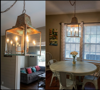 2 kitchen island pendant lights or Chandeliers in a living room and dining area with a table and chairs.