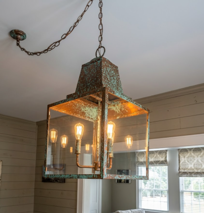 Vintage-style entryway kitchen island pendant light hanging in a room with neutral walls and a window.