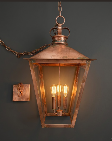 Raw Copper hanging foyer entryway kitchen island light or chandelier with glass panels on a dark background