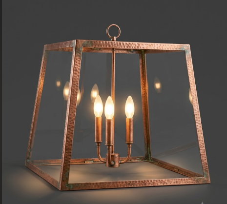 Copper foyer kitchen island pendant light fixture or chandelier with glass panels on a dark background