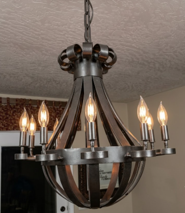 Metal copper foyer entryway kitchen island pendant light or chandelier with multiple light bulbs hanging from a ceiling.