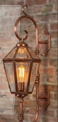 Vintage-style copper wall entryway light or lantern fixture on a red brick wall.