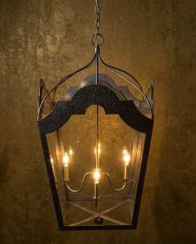 Decorative hanging pendant light or chandelier with glass panels on a textured wall background