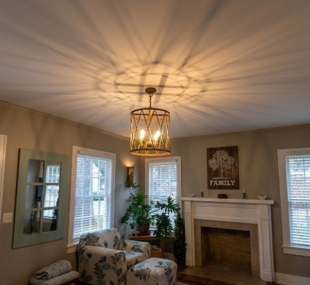 Living room with a chandelier, armchair, and fireplace.