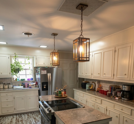Kitchen with white cabinets, stainless steel appliances, and pendant lights.