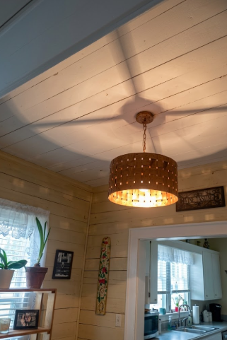 Ceiling Copper kitchen island pendant lights or chandeliers in a room with wooden paneling and a window.