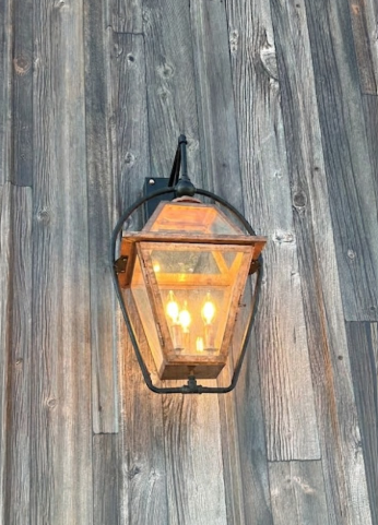 Vintage-style outdoor wall light fixture on the Faust Shope on a metal wall