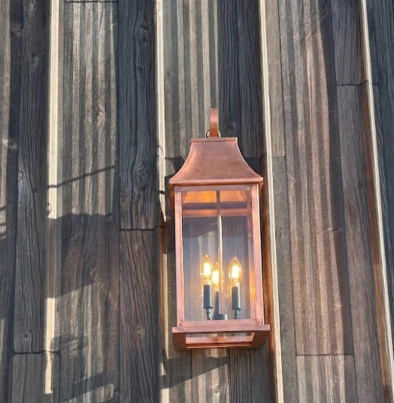 Copper wall-mounted lantern on a wooden wall
