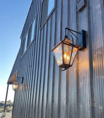 The Faust Shop metallic building exterior with wall-mounted lanterns