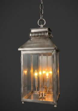 Copper pendant light lantern with glass panels on a dark background