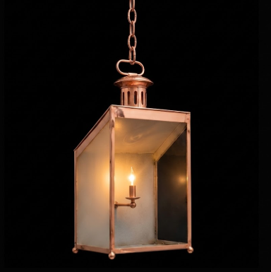 Vintage-style brass hanging pendant light lantern with a light bulb inside on a black background