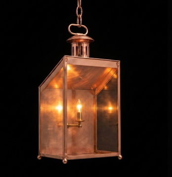Vintage-style brass hanging pendant light lantern with a light bulb inside on a black background