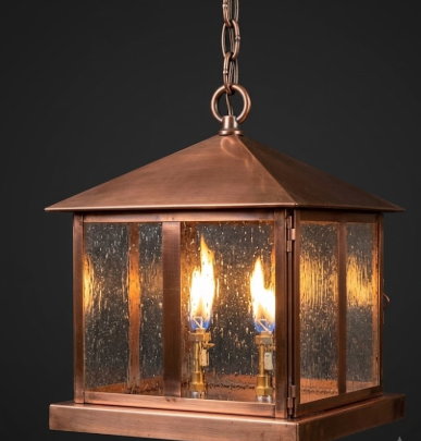 Raw copper pendant light with a dark background