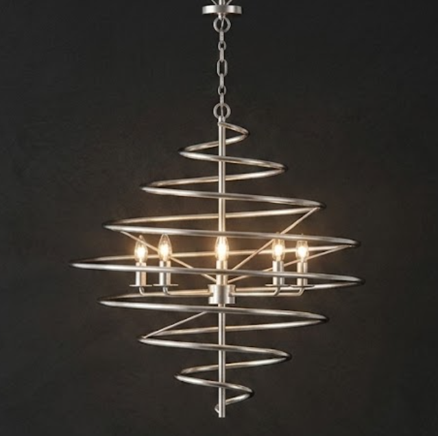 A modern spiral chandelier with a brushed silver metal frame and five lit candle-style bulbs, suspended against a dark charcoal background.